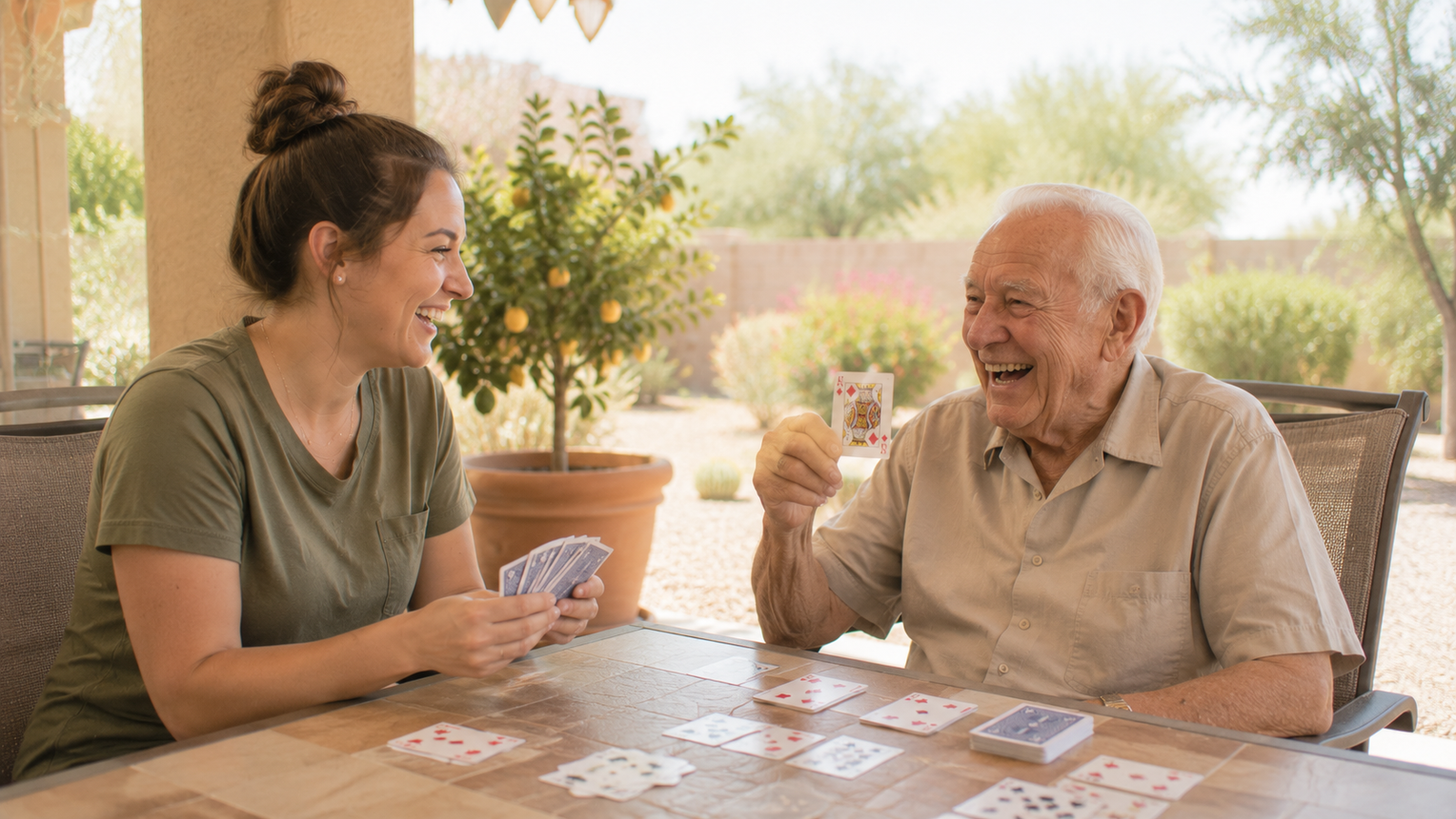 Hospice volunteer and patient laughing over a backyard card game